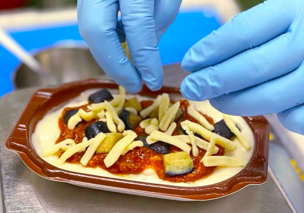 ピエトロのグラタン、手作業で盛り付けしている様子